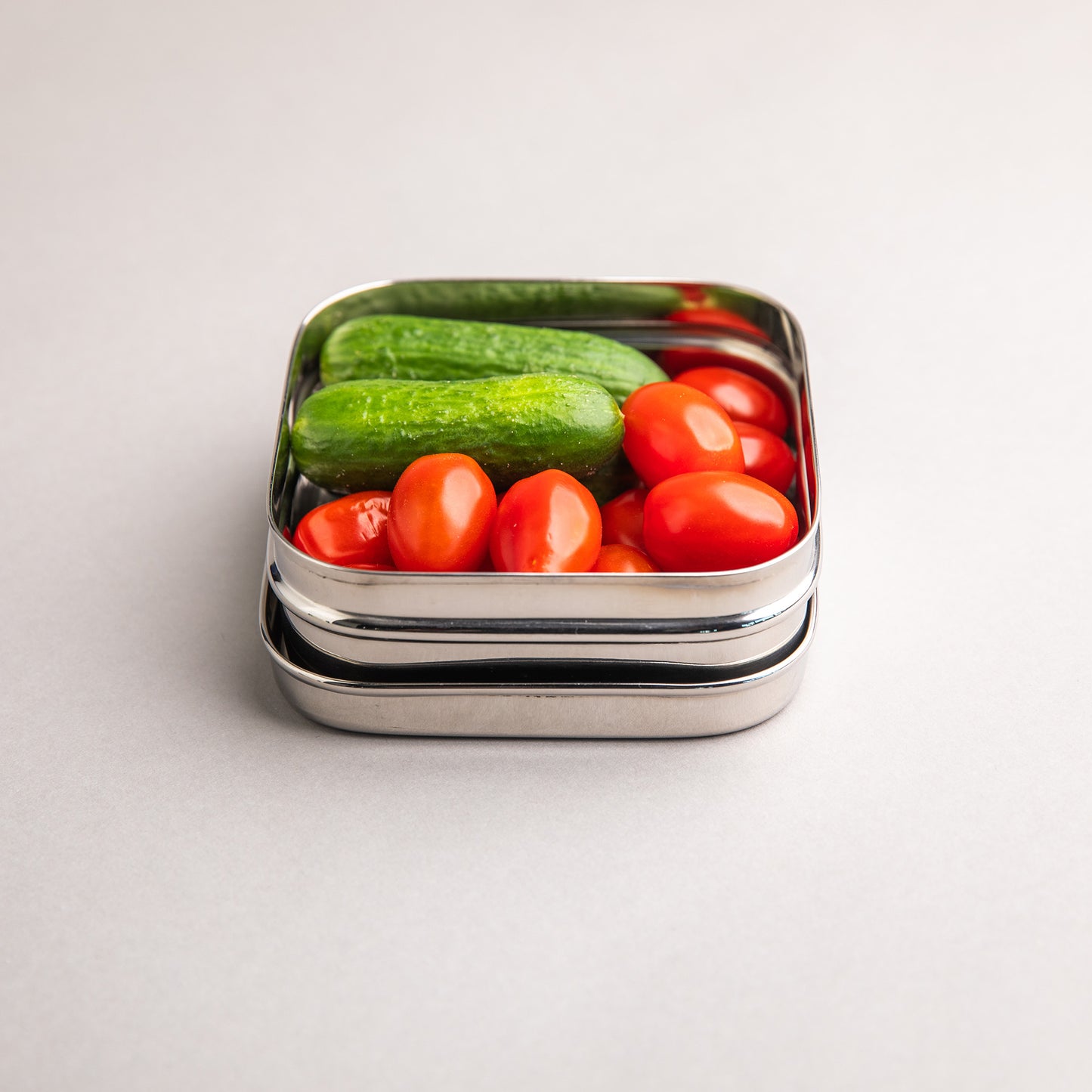 RVS snackbox gevuld met gezonde snacks zoals komkommer