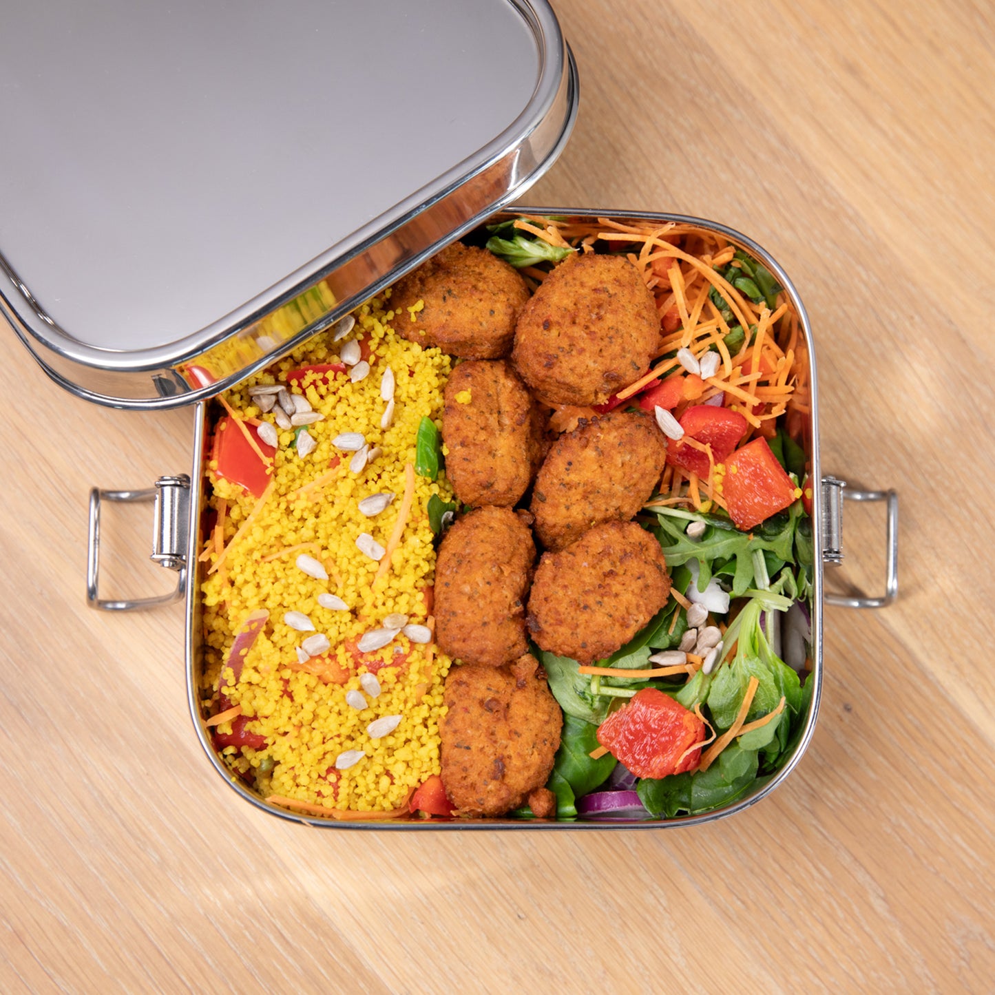 RVS lunchbox lekvrij van boven gevuld met een maaltijd salade.
