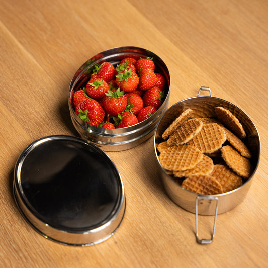 RVS bento lunchbox met vakken. gevuld met aardbeien en koekjes