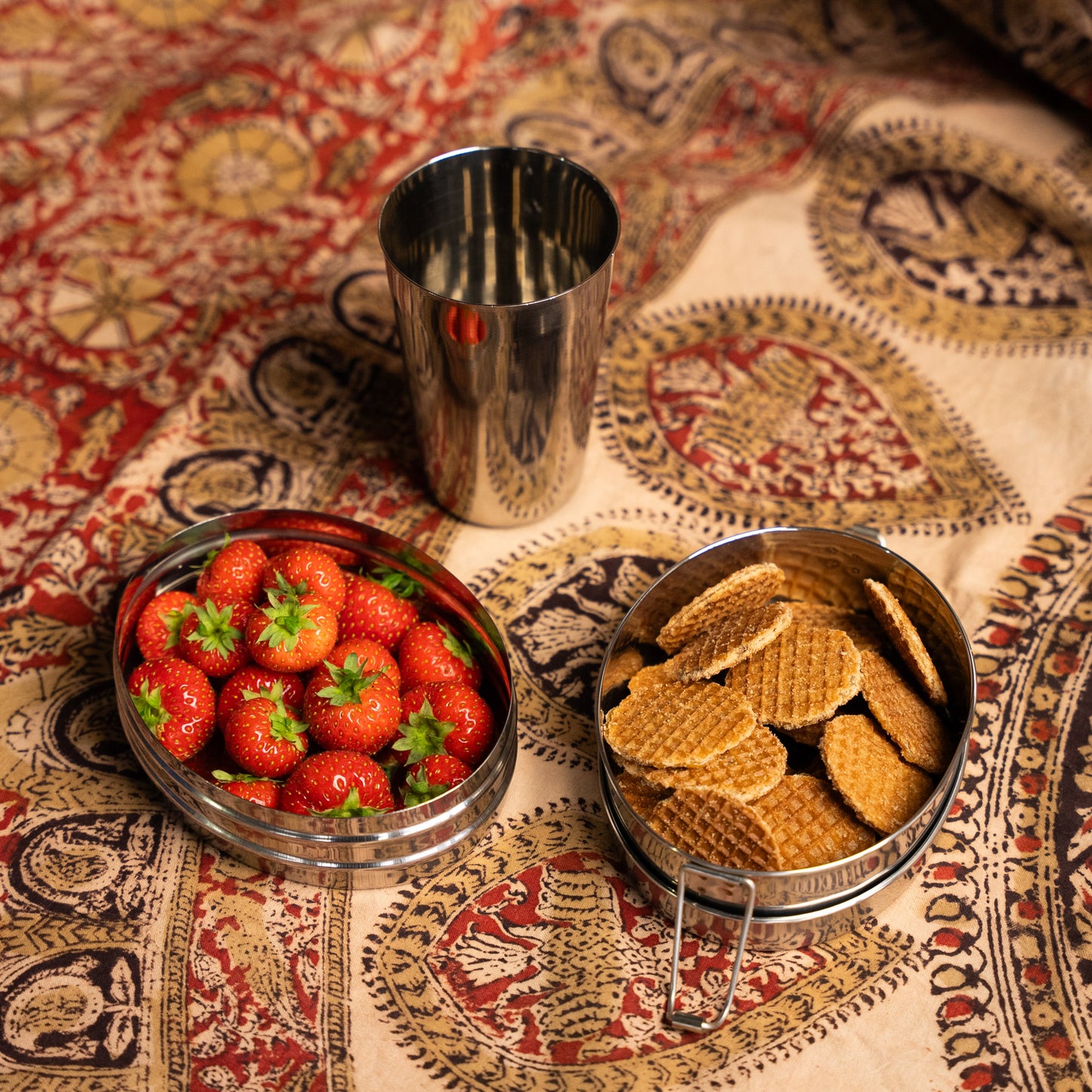 RVS glas, RVS lunchbox met vakjes op een Indiase doek