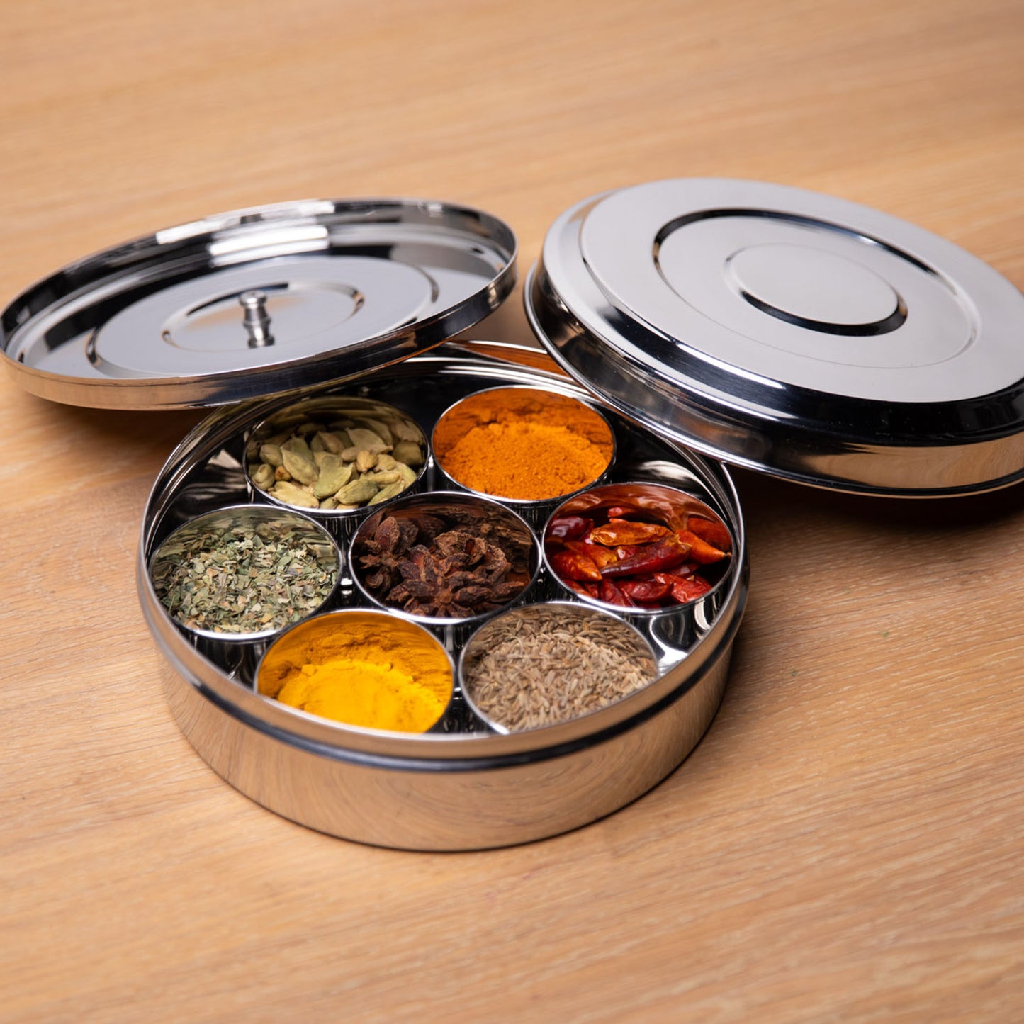 Masala Dabba open op een tafel met dekels erbij