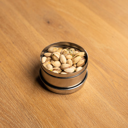 RVS voorraadpotje met pistachenoten op een houten tafel