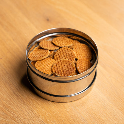 RVS voorraadpot gevuld met stroopwafels op een houten tafel