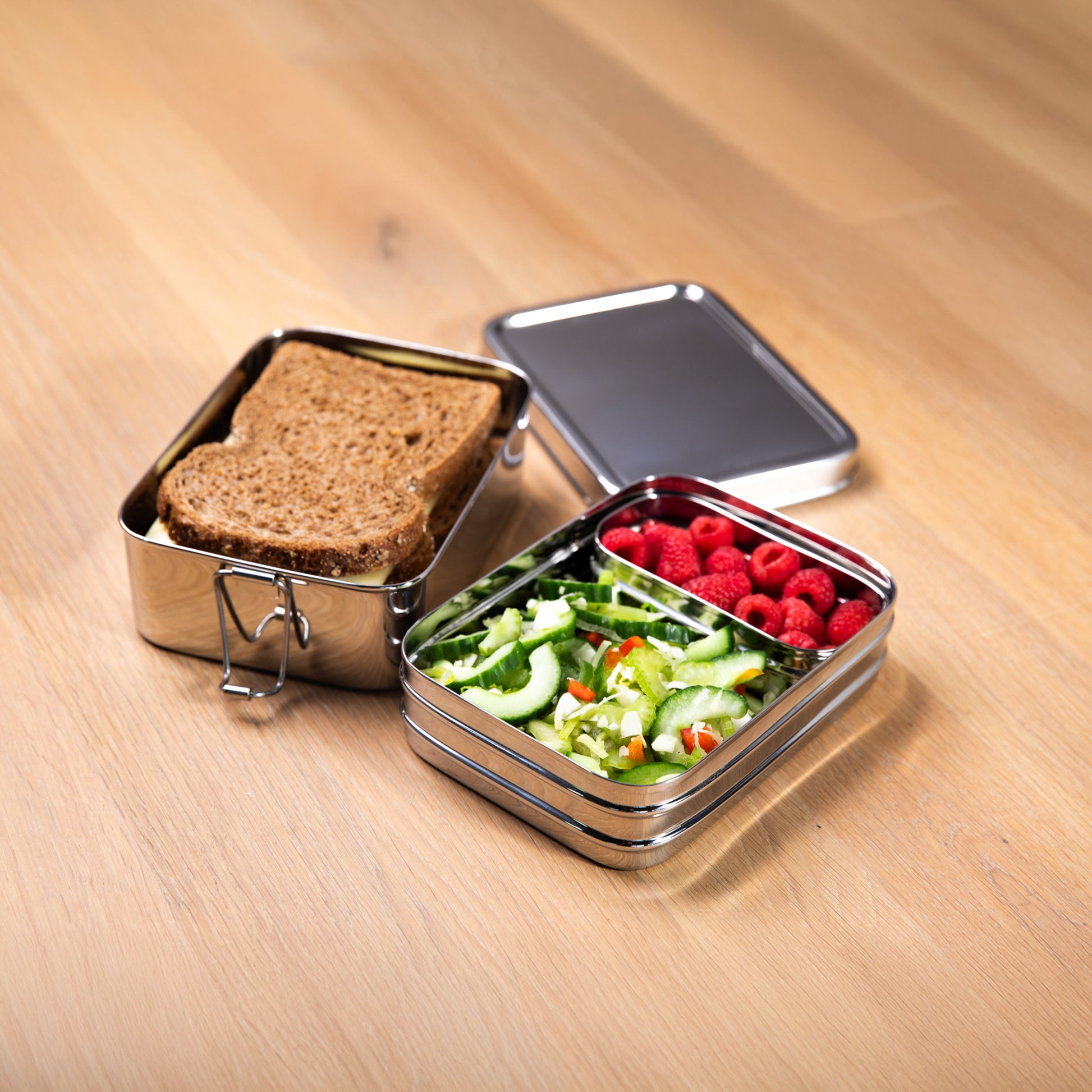 RVS Lunchbox met fruitbakje op een houten ondergrond